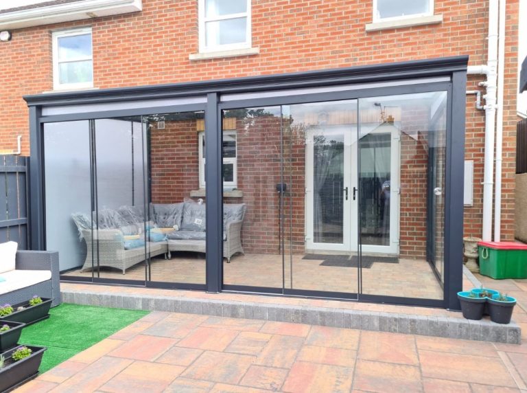 Grey Bosco veranda with glass sliding doors on a brick house
