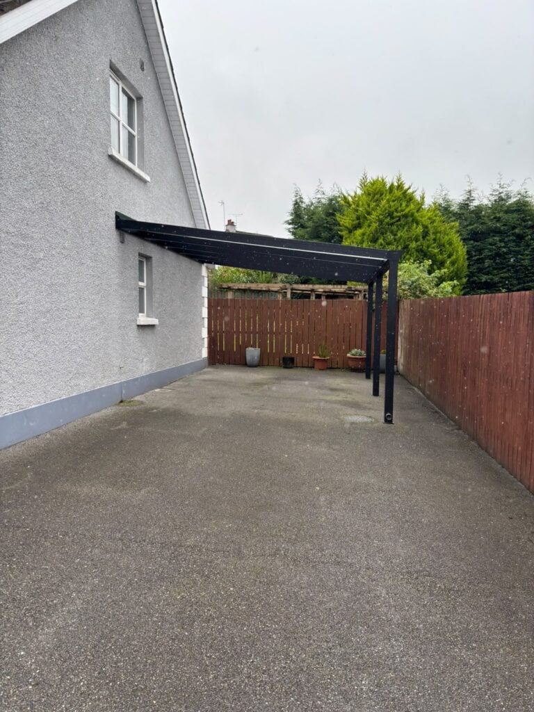 Carport over a driveway beside a fence