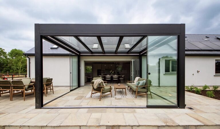 Grey Pinela glass pergola with glass sliding doors, built by Apex Verandas for DIY SOS: The Big Build Ireland in Kildare
