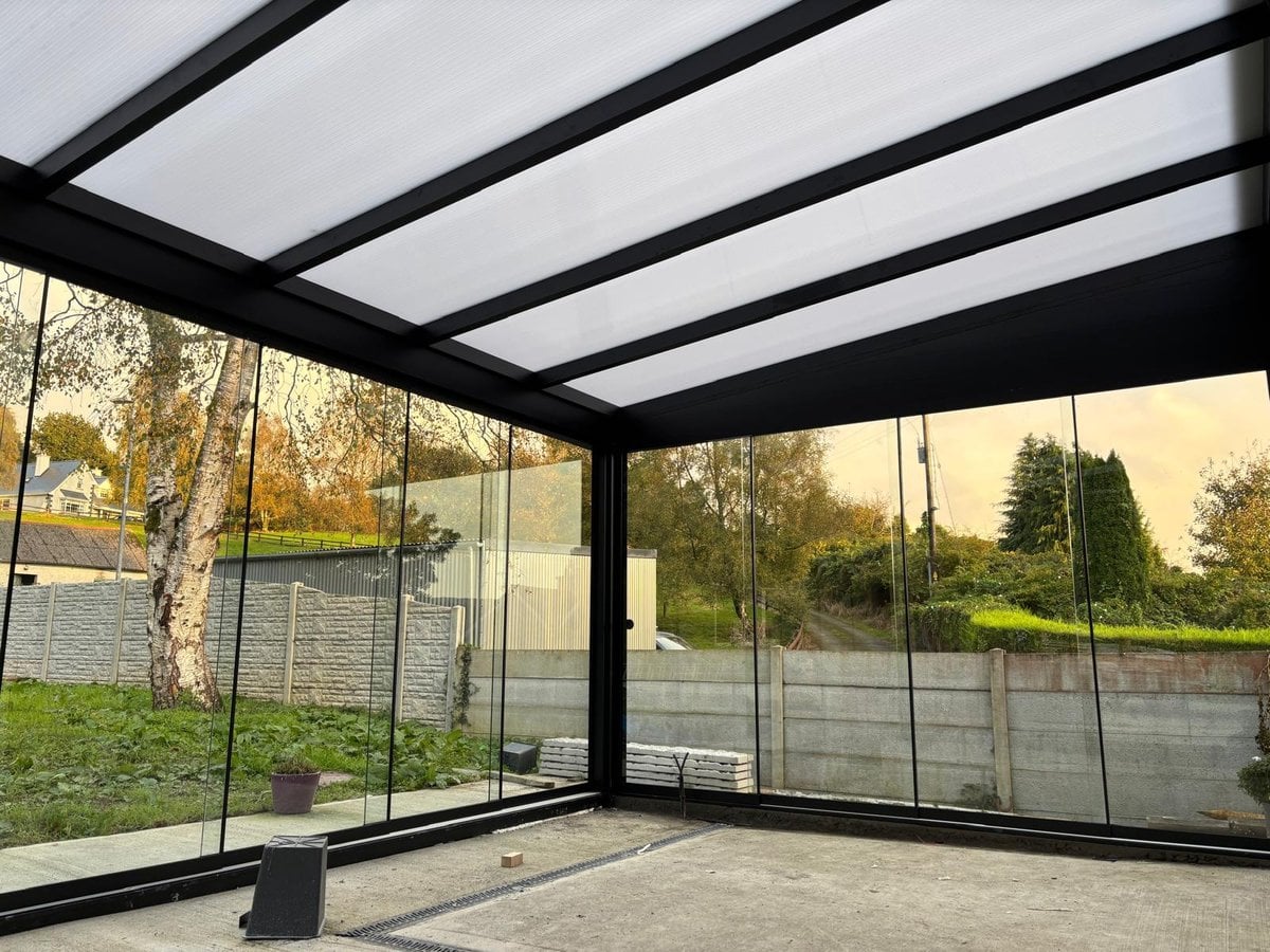 Inside a new glass room in Co. Clare, looking out through frameless glass sliding doors