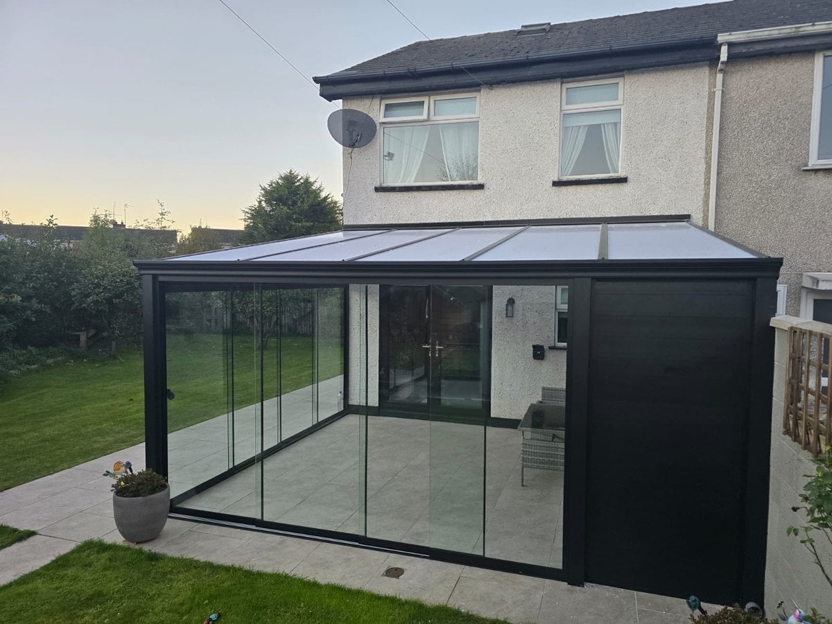 Black-framed glass room with glass sliding doors and a solid side wall on a semi-detached house in Dundalk, Co. Louth