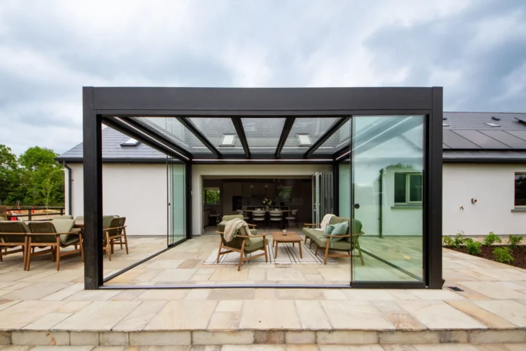 Grey glass-roof pergola with sliding glass doors, built by Apex Verandas for DIY SOS: The Big Build Ireland